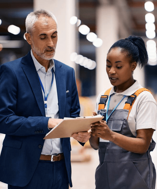 Factory manager closely working with a worker